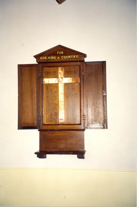 Wooden triptych, with triangular pediment and two hinged doors flank the central section, into which is set a copper cross