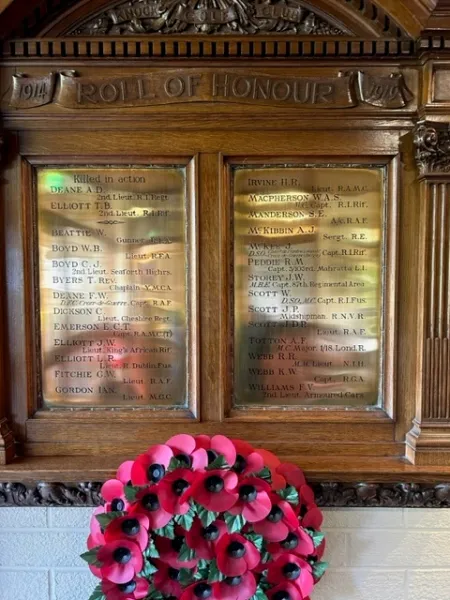Two brass plaques mounted on to a wooden frame