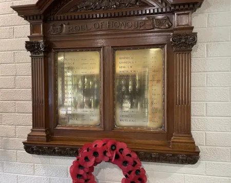 Two brass plaques on an ornate wooden board