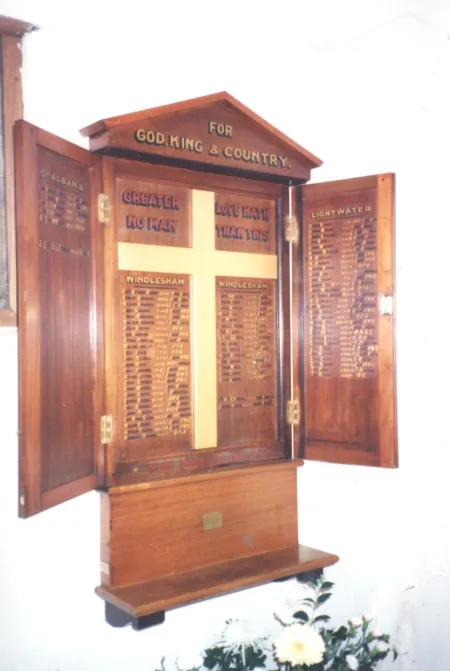 Wall mounted wooden triptych with doors and triangular pediment. Names within.