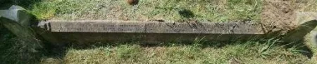 A kerb as part of a kerbed family plot with two names in addition to that remembered.