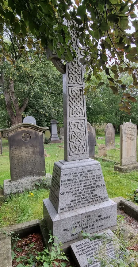 A granite Celtic Cross with an ornate Celtic design on a plinth over a family vault
