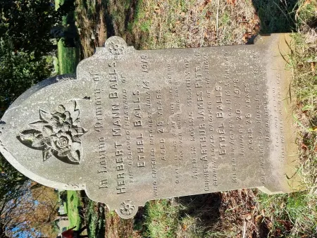 A lancet topped gravestone with small curved shoulders with the inscription below a foliated engraving and one name in addition to that remembered