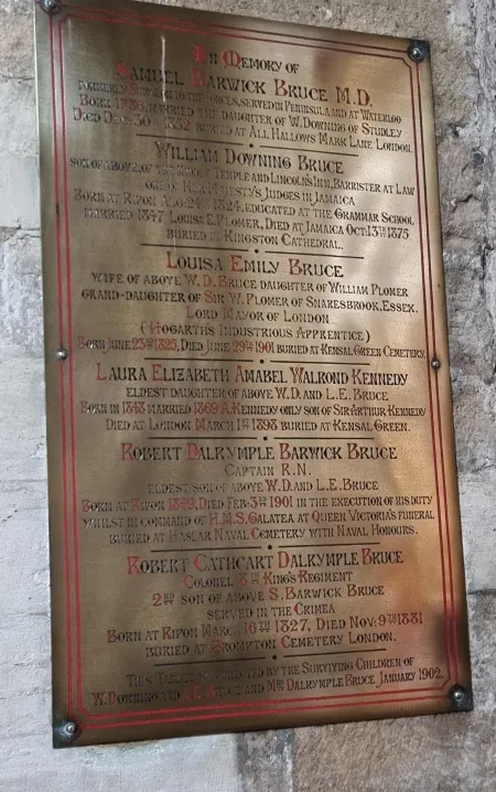 A brass family plaque with gold and red lettering and five names in addition to that remembered