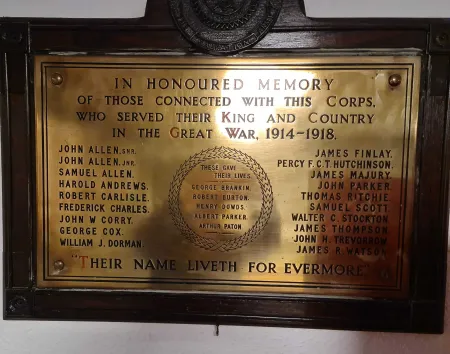 Brass plaque mounted on wooden board
