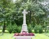 Celtic cross on a plinth with trees behind