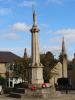 Octagonal three-stepped base surmounted by an octagonal plinth with eight inscription panels. Rising from the plinth is a tapering stout octagonal pillar with a caped standing figure of St. George holding a bronze lance.