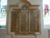 Nowy headed stone tablet split in to three columns each bordered by a foliate design. 
