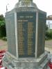 Tall cross with a sword of sacrifice standing on an octagonal plinth and four stepped octagonal base. The names on the slate tablets are picked out in gold lettering.