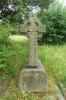 A rough hewn Celtic cross set upon large inscribed footstone