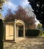 Portico on pillars surrounded by paving and trees