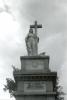 Statue of figure holding cross.