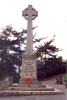 Celtic cross with wreaths laid at its base.