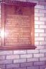 Wooden board with list of engraved names fixed to wall.