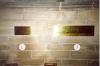 Two brass plaques fixed to stone wall.