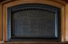 Bronze plaque with names set inside wood paneling.