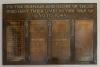 Plaque on wall with four columns of names.