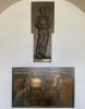 Brass plaque with four columns of names and separate plaque above with relief figure of soldier leaning on rifle.