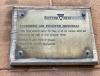 Brass plaque explaining the window on the exterior of Lockerbie Town Hall