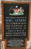 Plaque fixed to wooden backboard.