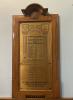 Brass plaque in a wooden frame