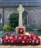 Celtic cross on base with plinth and poppy wreaths