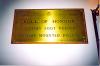 Plaque fixed to wooden backboard