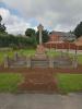 Cross in field surrounded by pillars and chains