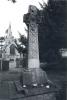  A limestone wheel cross on a stepped and battered rectangular stone pedestal and rectangular base, with additional stone tablets at each of the four faces of the base.