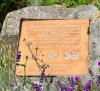 Plaque within flower bed on east side of memorial