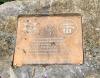 Plaque within flower bed on western side of memorial