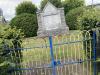 Stone tablet on rough hewn base. Celtic cross in relief.