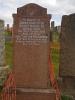 Standing red granite gravestone with metal lettering 