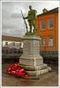 Bronze figure of soldier standing at ease, atop plinth with three step base