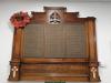 Wooden board with three columns of names.