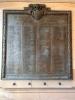 Large bronze plaque mounted on indoor wall. Inscribed in raised letters are names of 'the men of Hamilton who have their lives 1914-1918'. A crest and insignia is atop the plaque. A decorative border surrounds three sides of the plaque.