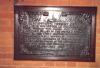 Plaque mounted on wooden backboard