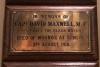Brass plaque mounted on a wooden board
