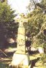 Cross with shield carved in relief on tapering plinth, tapering base