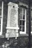 White stone tablet with inscribed names and embedded clock