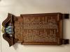 Wooden board with names in white letters, crest at top