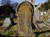 Ornate arch-top gravestone with leaded lettering.