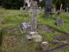 Cross shaped gravestone on a large square grave plot.