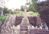 Rough hewn stone wheel cross in stone enclosure