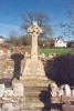 Rough hewn stone wheel cross in stone enclosure