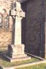 Celtic cross on rough hewn base on two steps with inscriptions inset on base