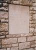 Stone tablet mounted within stone wall