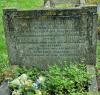 A kerbed grave with an oblong stone gravestone with an inverted checked top and two names in addition to that remembered.
