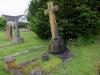 Kerbed grave with ornate cross headstone.