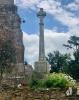 Celtic cross and column mounted on stone wall